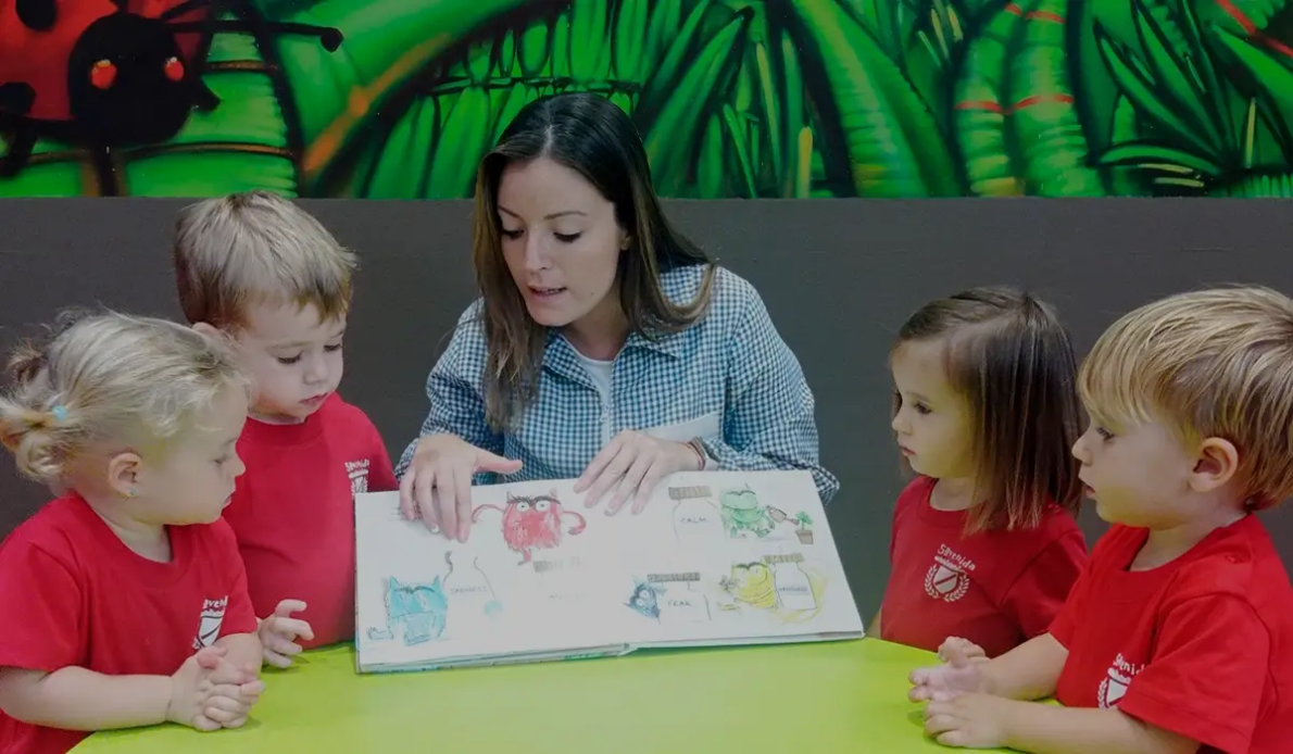 educator teaching English to young children at a nursery school