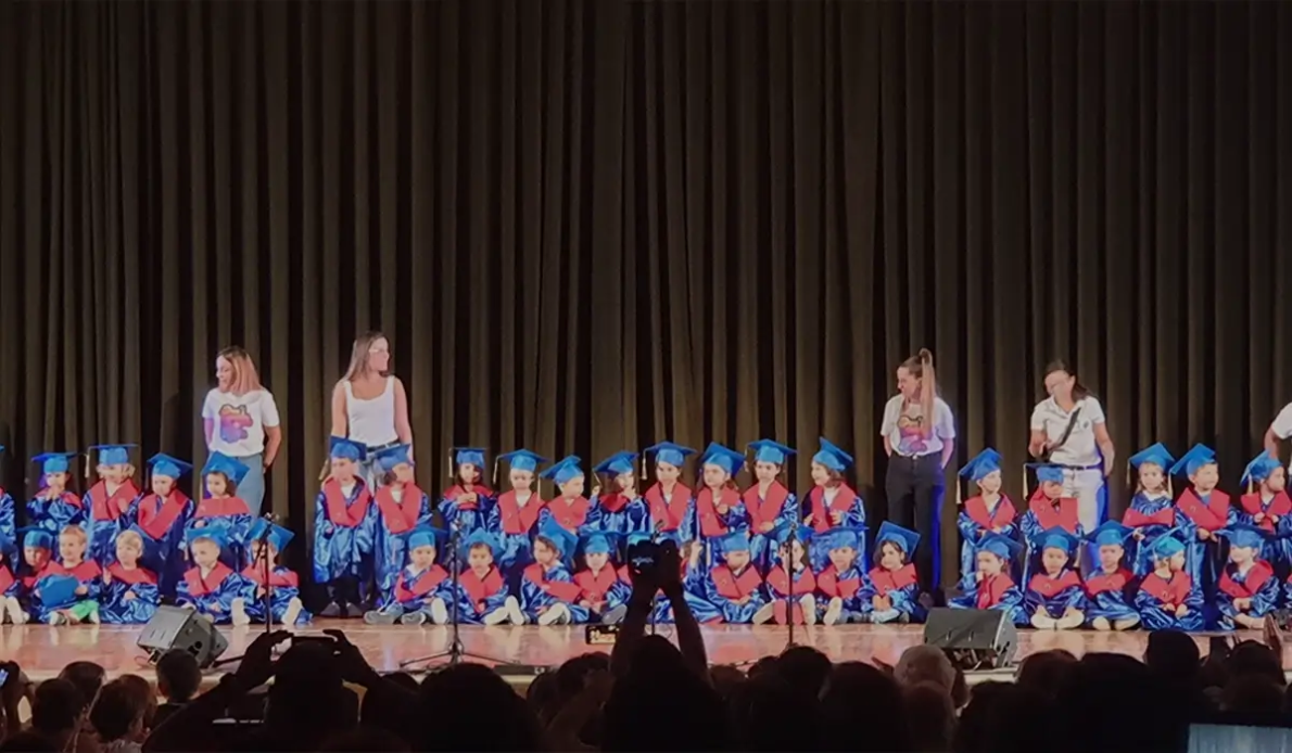 kindergarten students at graduation ceremony with cap and gown scholarship