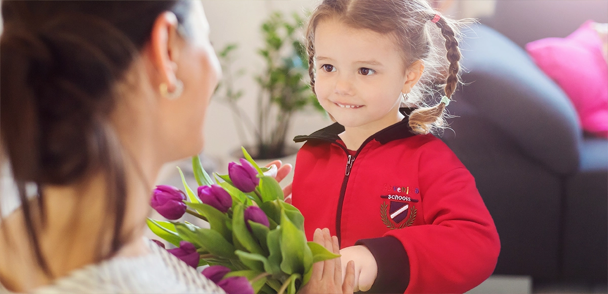 niña de escuela infantil regalando un ramo de flores a su madre
