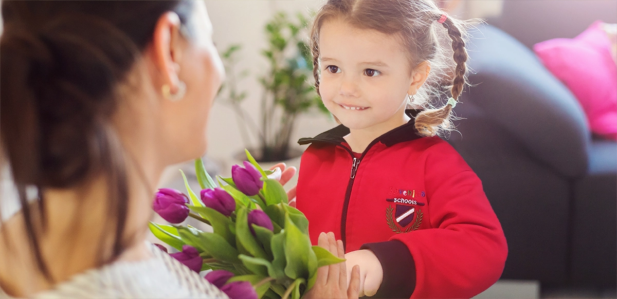 kindergarten girl giving a bouquet of flowers to her mother