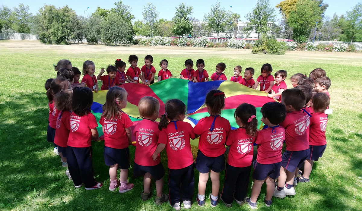 enfants de l'école maternelle jouant avec un parachute