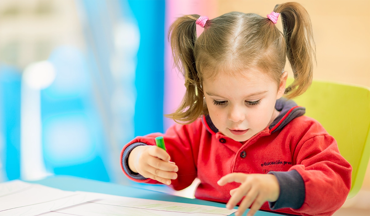 girl in kindergarten uniform drawing