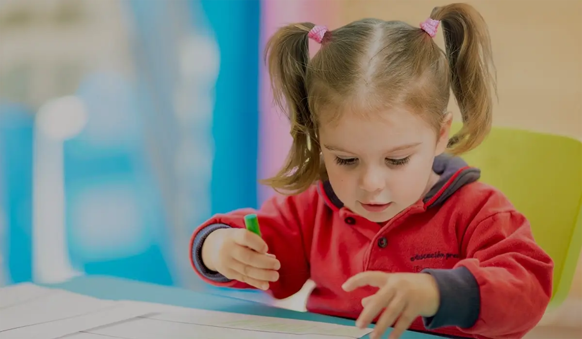 niña con uniforme de escuela infantil dibujando